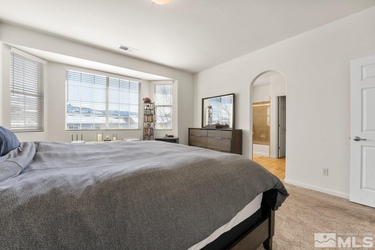 11022 Colton Drive Reno, NV 89521 - Photo 15 of 26 a bedroom with a large bed and a large window