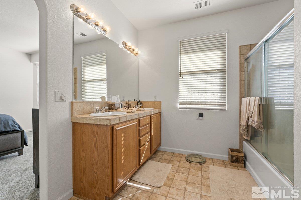11022 Colton Drive Reno, NV 89521 - Photo 16 of 26 a bathroom with a sink a mirror and a bathtub