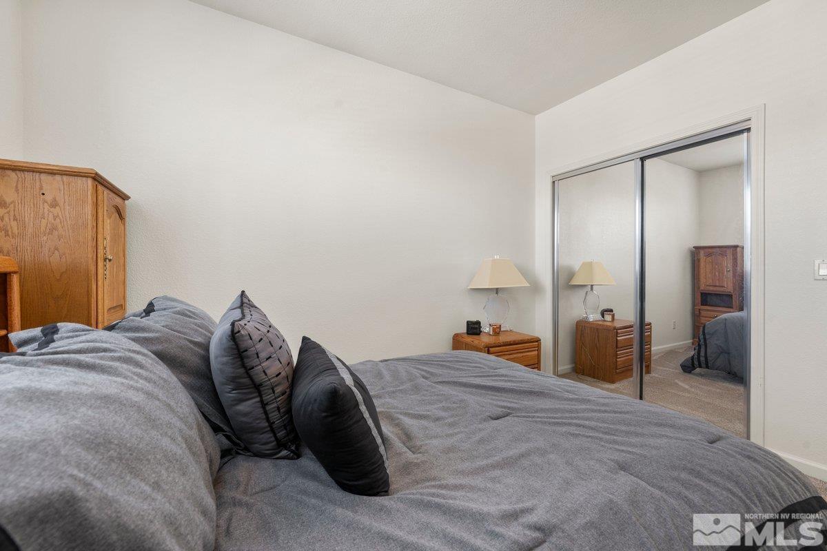 11022 Colton Drive Reno, NV 89521 - Photo 19 of 26 a bed room with a bed and a mirror
