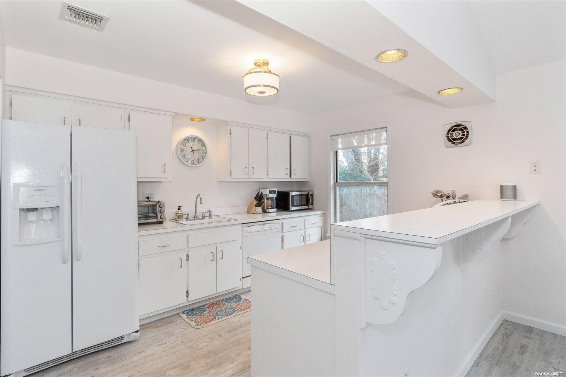 37 Halsey Road Remsenburg, NY 11960 - Photo 6 of 17 a kitchen with white cabinets and refrigerator