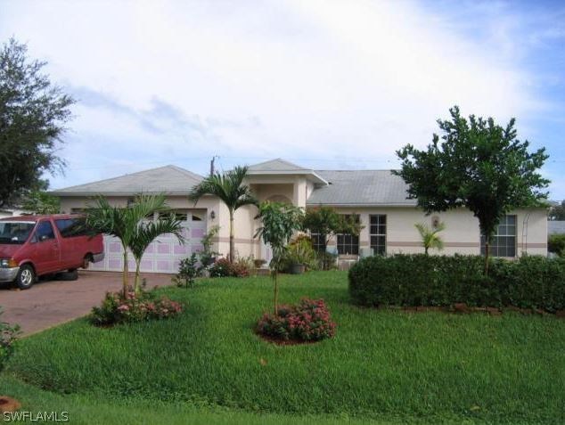 8426 Butternut Road Fort Myers, FL 33967 - Photo 3 of 4 a front view of a house with a garden and plants