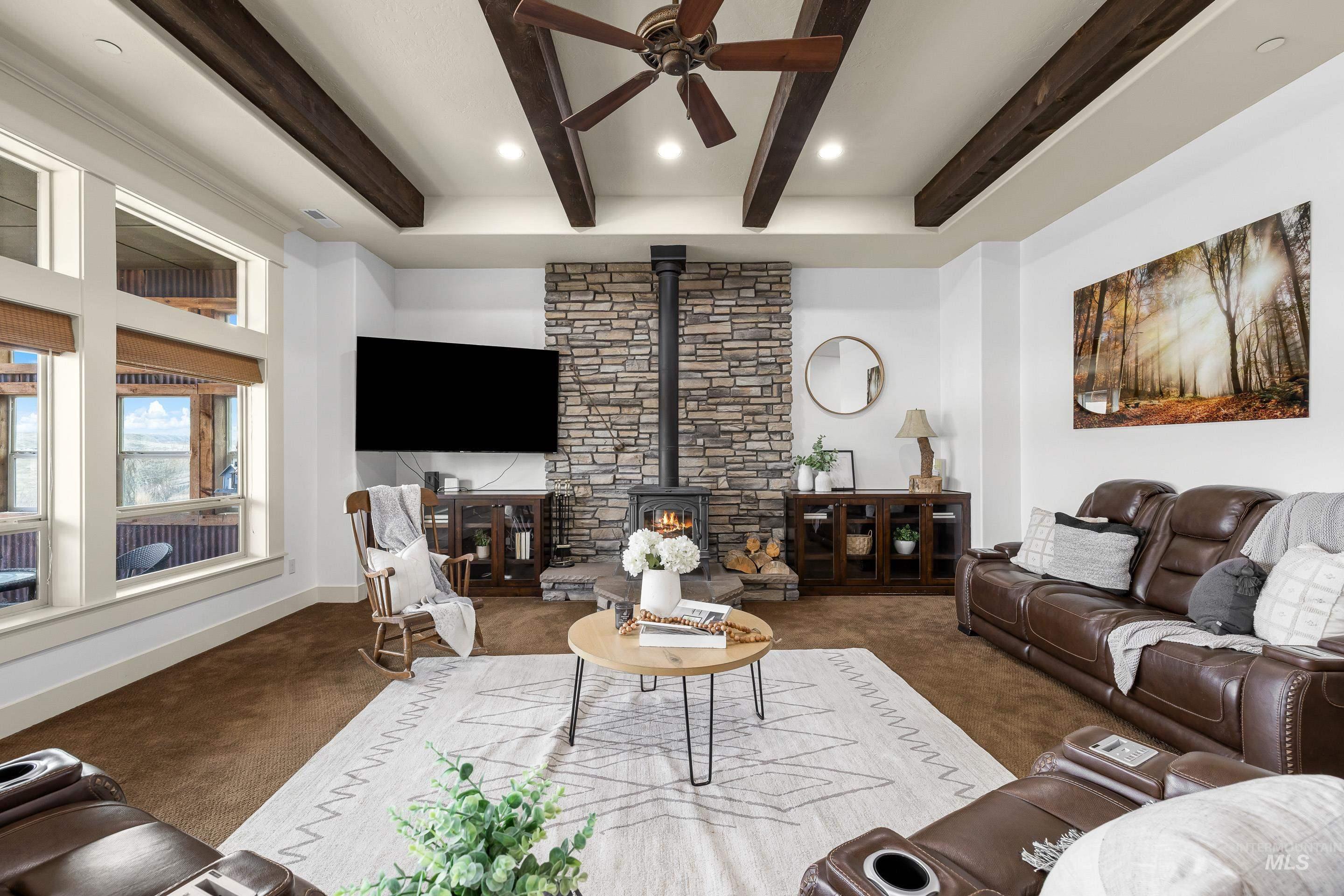 7521 North Grand Ridge Lane Eagle, ID 83616 - Photo 11 of 50 Living area featuring a ceiling fan, a wood stove, carpet floors, beamed ceiling, and recessed lighting