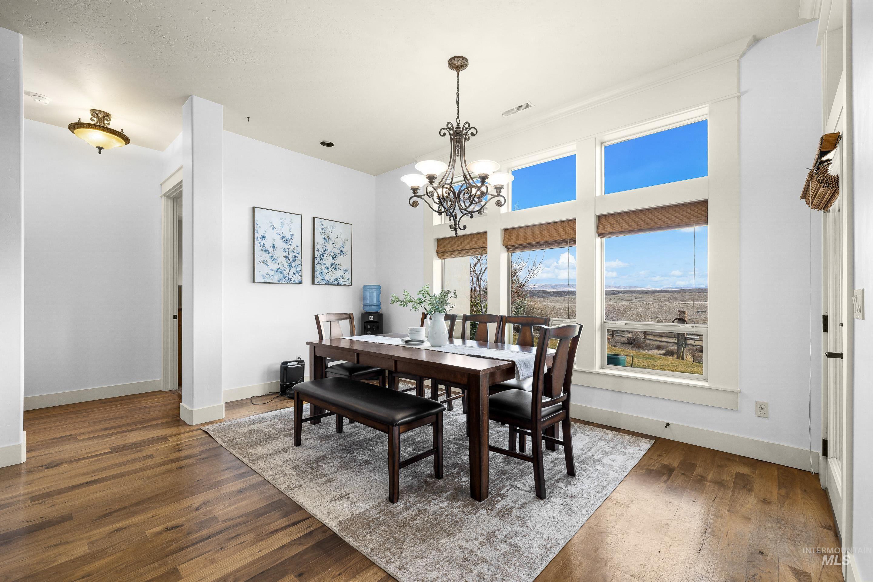 7521 North Grand Ridge Lane Eagle, ID 83616 - Photo 23 of 50 Dining space with dark wood-style flooring, hanging lights, and a high ceiling