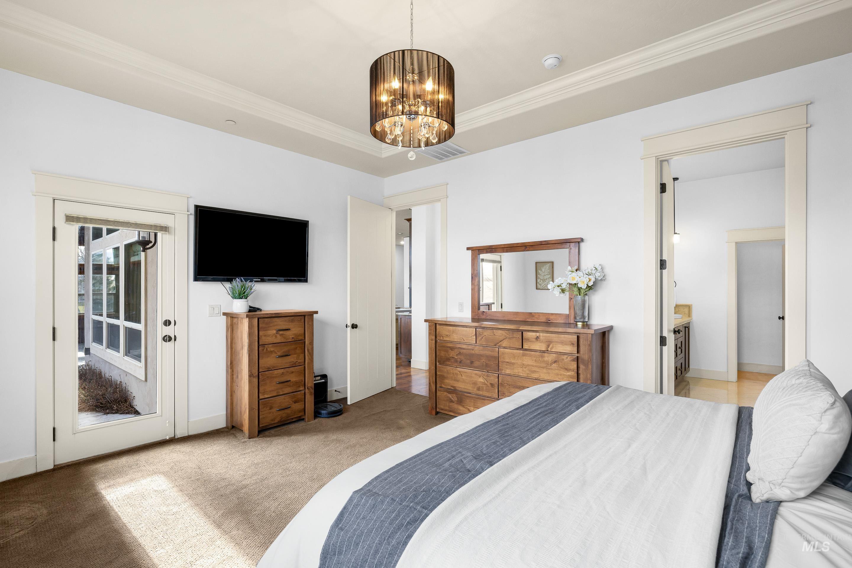 7521 North Grand Ridge Lane Eagle, ID 83616 - Photo 26 of 50 Bedroom featuring carpet flooring, ornamental molding, suspended lighting, multiple windows, and access to exterior