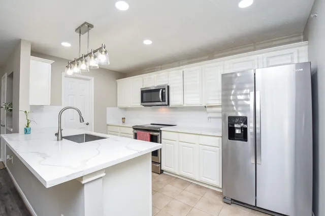 a kitchen with stainless steel appliances a sink stove and refrigerator