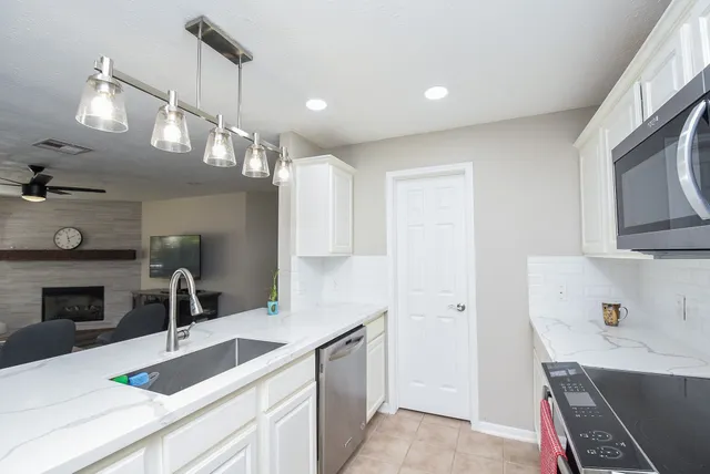 a kitchen with kitchen island a sink appliances and cabinets
