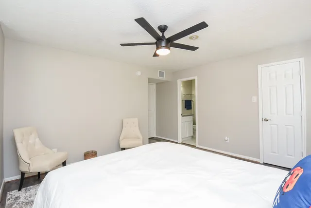 a bedroom with a large bed and a chandelier