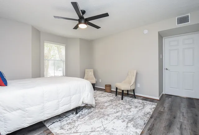 a bedroom with a bed a chair and a window