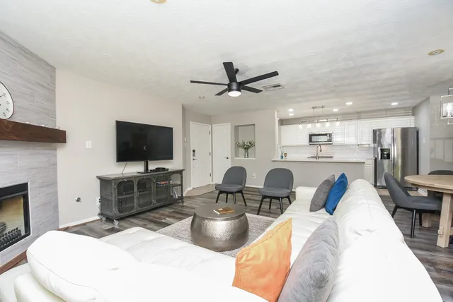 a living room with furniture a flat screen tv and kitchen view