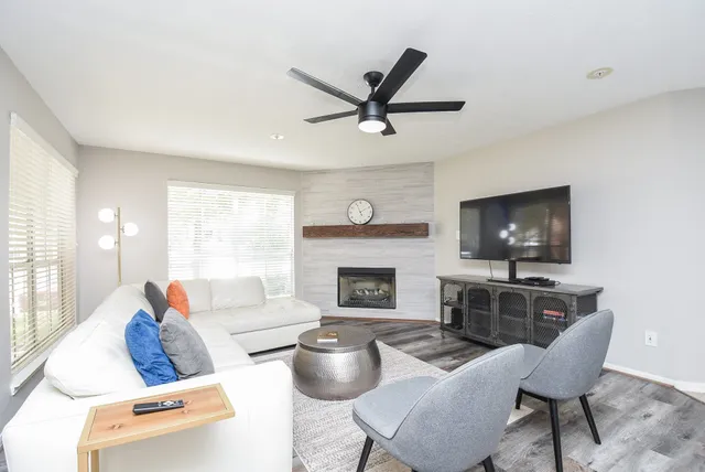 a living room with furniture a fireplace and a flat screen tv