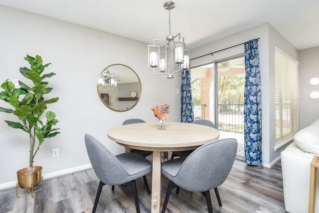 a dining room with furniture a chandelier and wooden floor
