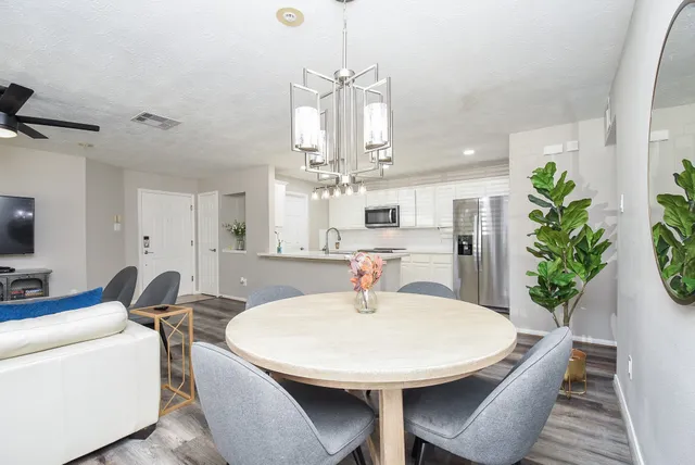 a view of a dining room with furniture and a chandelier