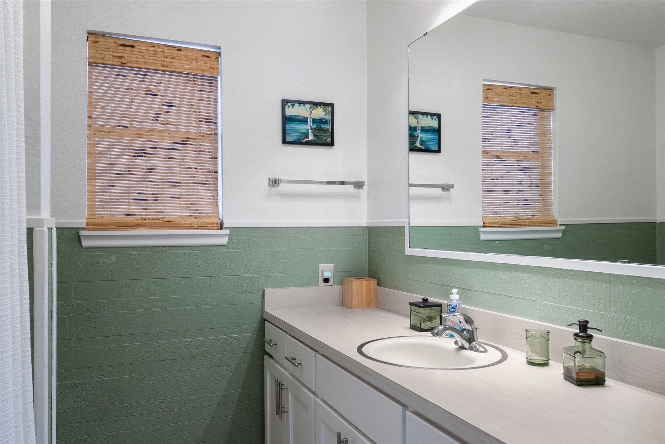 141 Perry Lane Kingsland, TX 78639 - Photo 31 of 40 A well-appointed bathroom features a single vanity and a large mirror extending across the wall.