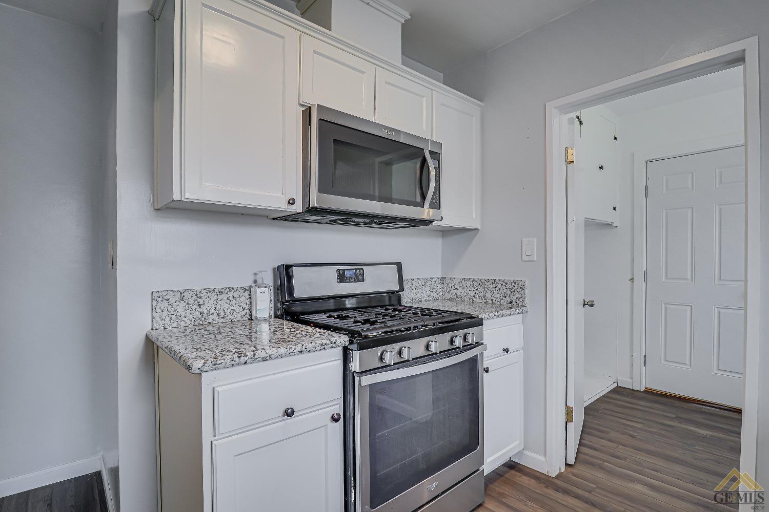 Undisclosed Address Bakersfield, CA 93308 - Photo 14 of 24 a kitchen with stainless steel appliances granite countertop a stove microwave and sink