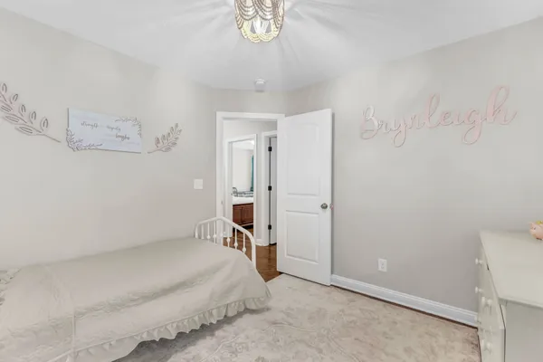 a spacious bedroom with a bed and a chandelier