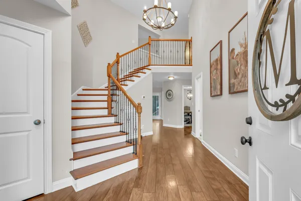 a view of a hallway with wooden floor and staircase