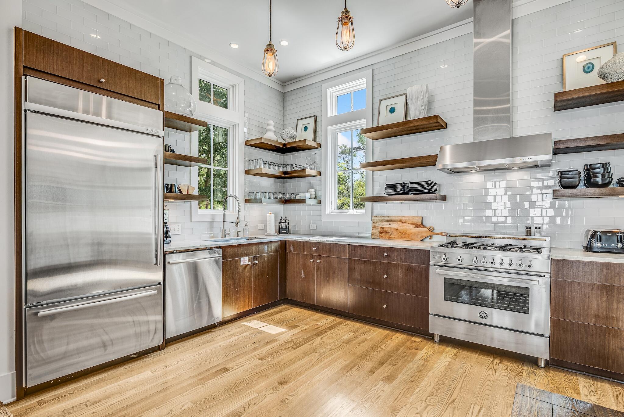 76 North Winston Ln Inlet Beach Inlet Beach, FL 32461 - Photo 9 of 48 a kitchen with stainless steel appliances granite countertop a refrigerator a stove and a sink with wooden floor