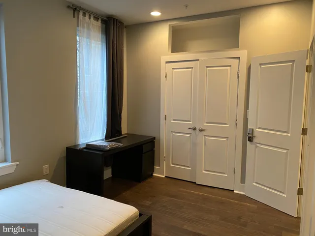 a bedroom with a bed and two windows