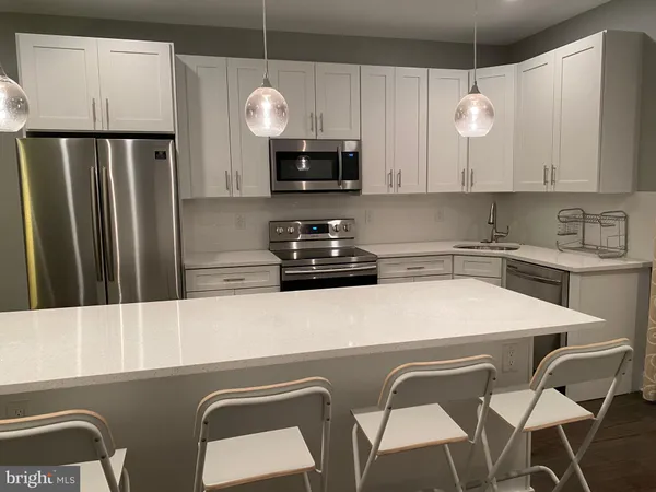a kitchen with stainless steel appliances a stove a sink and a refrigerator