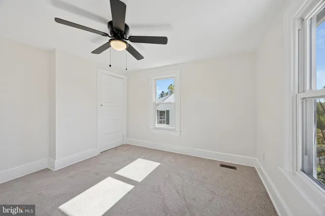 a view of room with hardwood floor and ceiling fan
