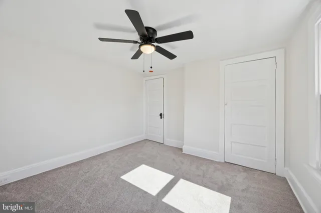an empty room with window and a ceiling fan
