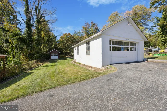 a view of residential houses with yard and road