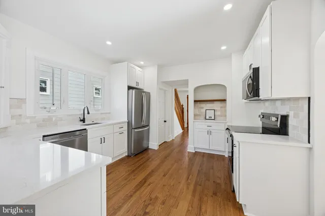 a kitchen with stainless steel appliances a stove a sink a refrigerator and cabinets