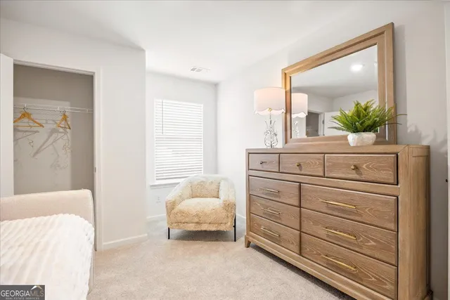 a bedroom with a bed and a mirror on dresser