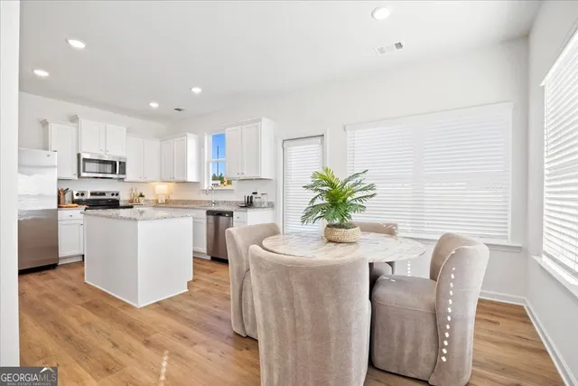 a kitchen with white cabinets and stainless steel appliances