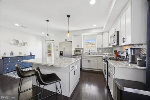 a kitchen with a white cabinets and chairs