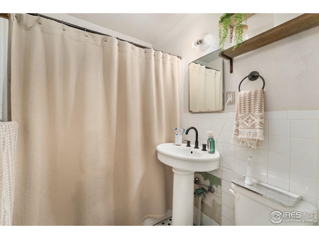 7908 Stuart Place Westminster, CO 80030 - Photo 17 of 30 a bathroom with a sink a mirror and a shower curtain