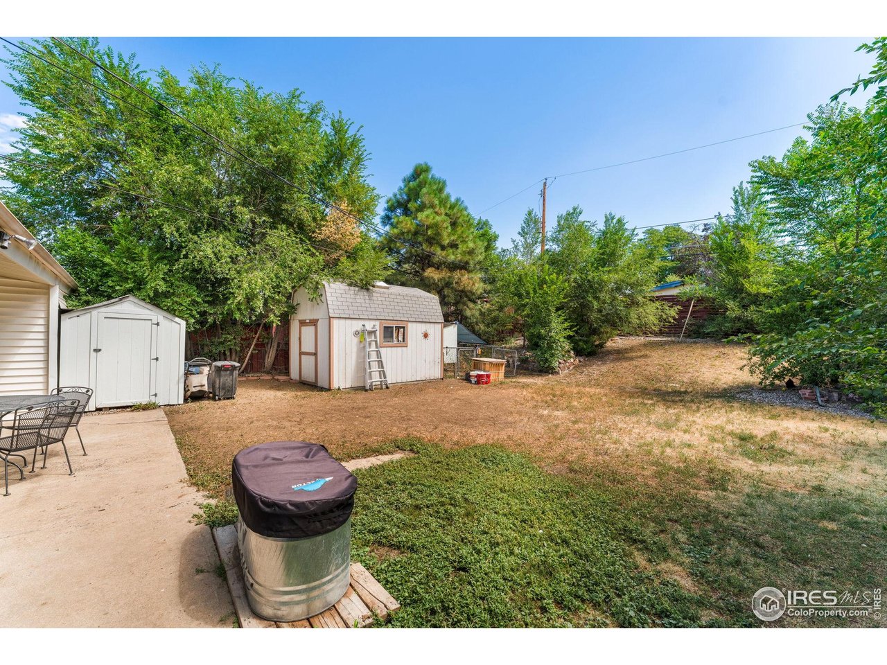 7908 Stuart Place Westminster, CO 80030 - Photo 23 of 30 a view of a backyard with table and chairs and a large tree