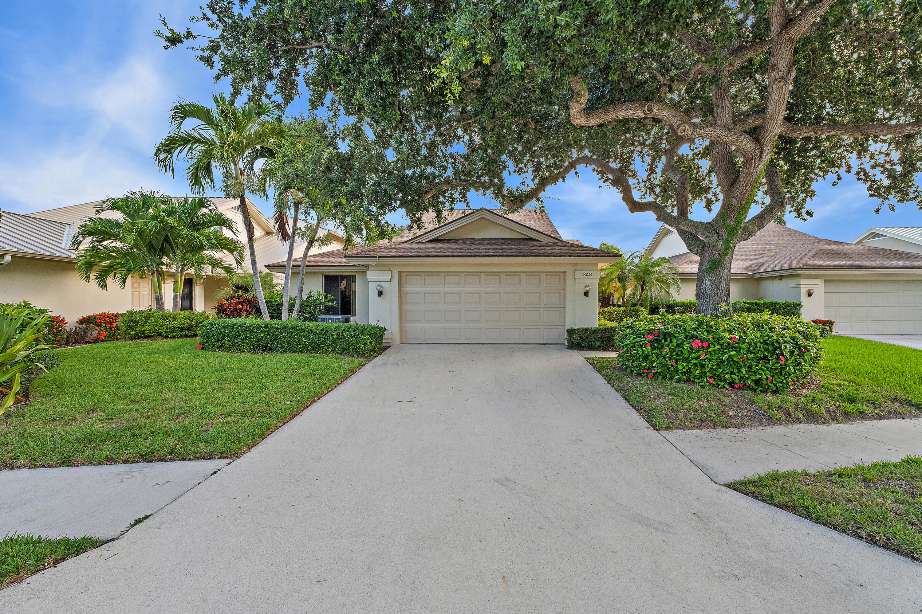 348 River Edge Road Jupiter, FL 33477 - Photo 8 of 30 a front view of a house with a garden and trees