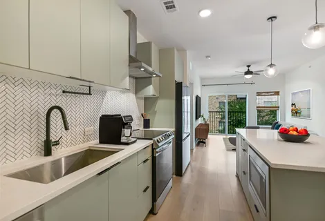 a kitchen with stainless steel appliances a sink a stove and a wooden floor