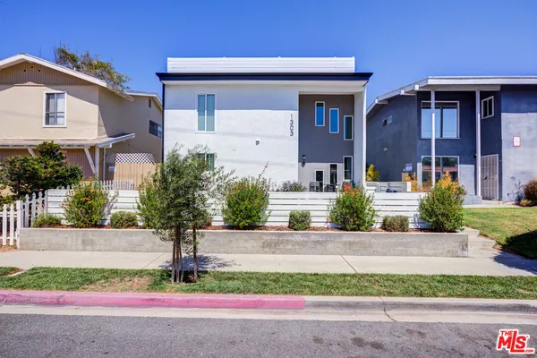 a front view of a house with garage and plants