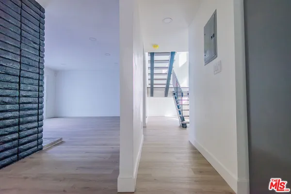 a view of a hallway with wooden floor and stairs