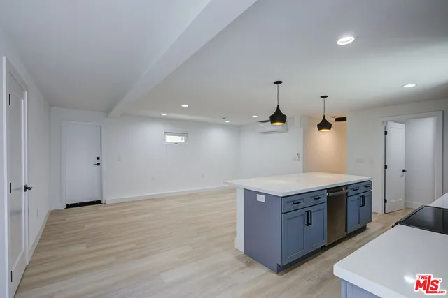 a kitchen with a stove and a wooden floor