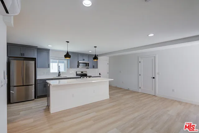 a kitchen with stainless steel appliances a refrigerator sink and cabinets