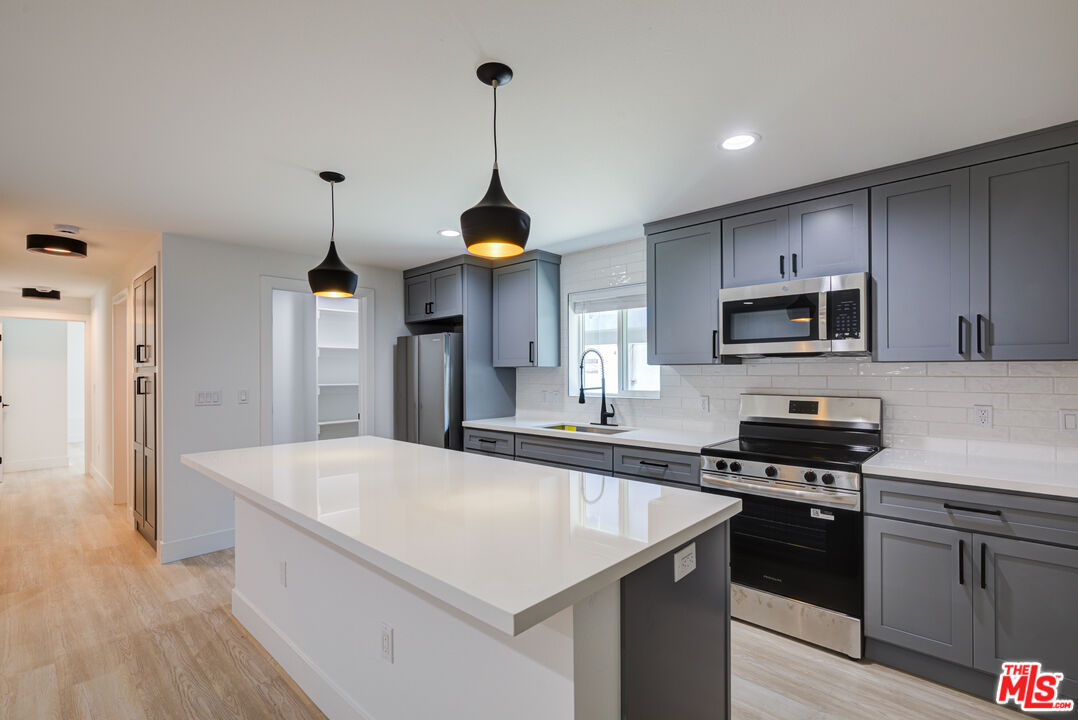 1303 Beryl Street Redondo Beach, CA 90277 - Photo 10 of 31 a kitchen with stainless steel appliances granite countertop a sink a stove and a wooden floors