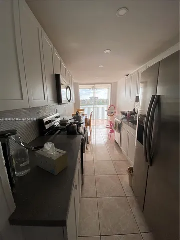 a kitchen with stainless steel appliances granite countertop a sink a stove and a refrigerator