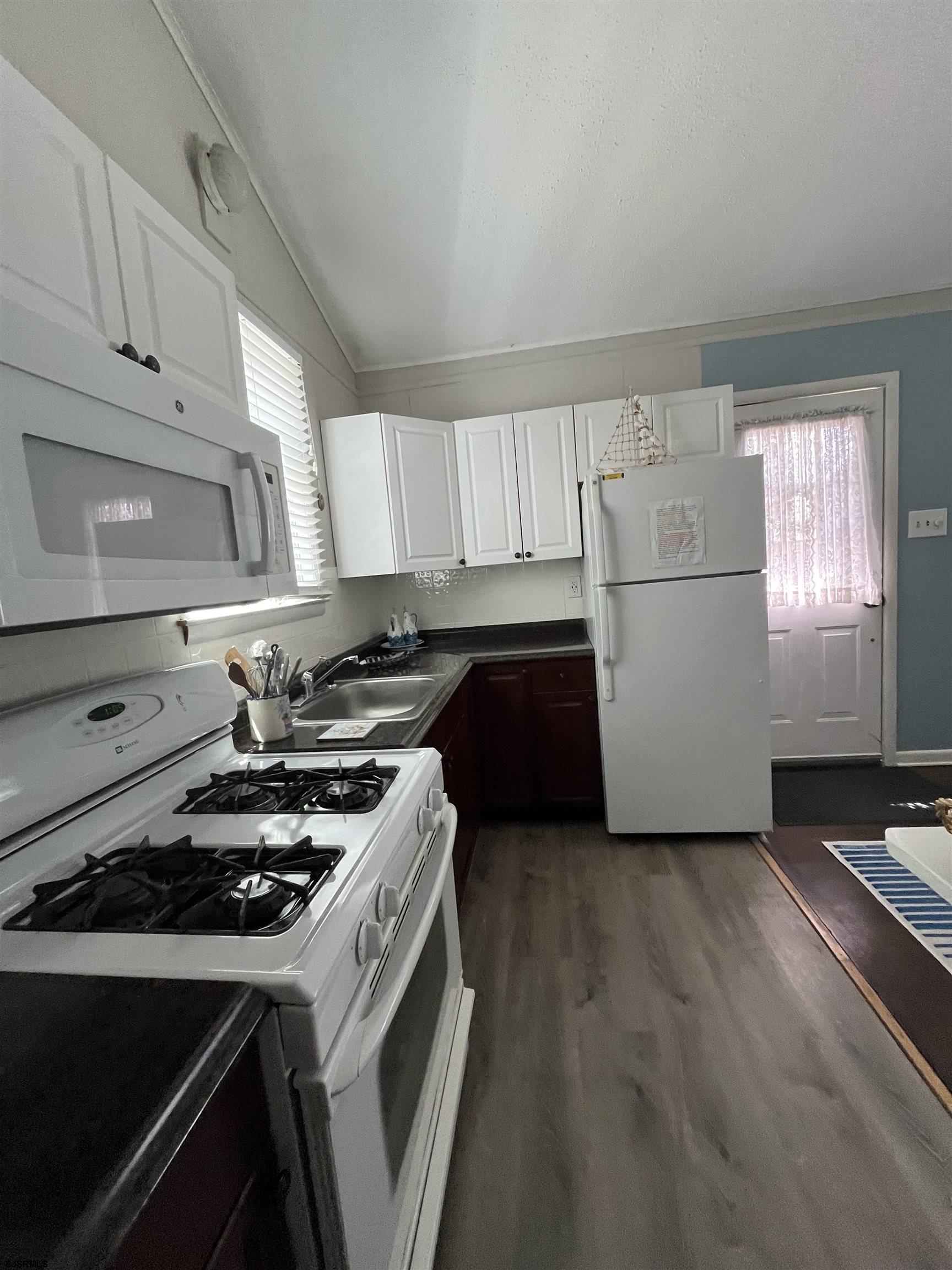 509 East 4th Street, Unit COTTAGE Ocean City, NJ 08226 - Photo 10 of 13 a kitchen with a stove a sink and a refrigerator
