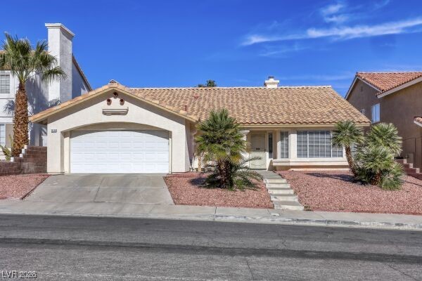 1536 Pony Ranch Circle Henderson, NV 89014 - Photo 1 of 23 Mediterranean / spanish home featuring a chimney, a tile roof, an attached garage, driveway, and stucco siding