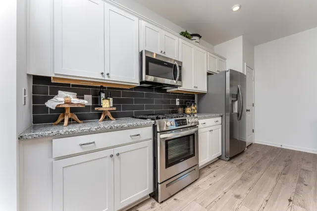 a kitchen with stainless steel appliances granite countertop a stove a refrigerator and a microwave