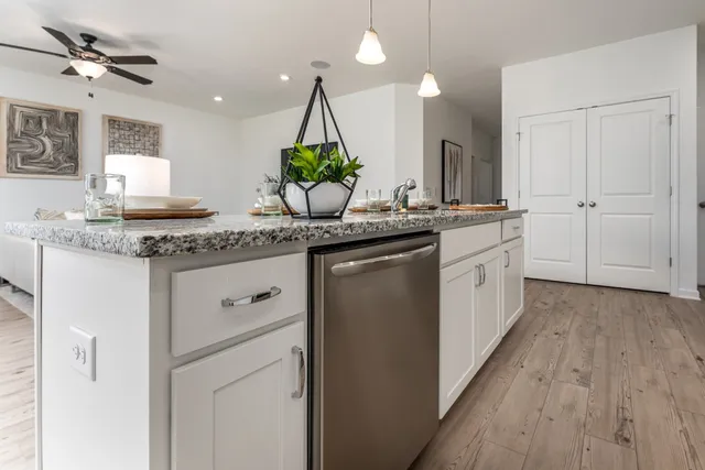 a kitchen with stainless steel appliances granite countertop a sink a stove and a wooden floors