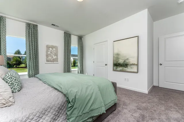 a bedroom with a bed and a painting on the wall