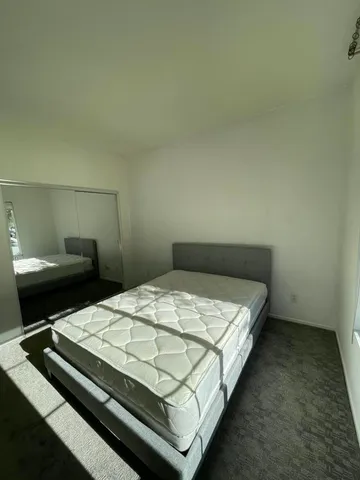 a bed sitting in a bedroom next to a larger window