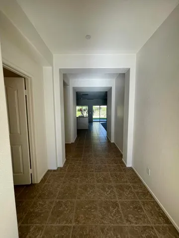 a view of a hallway with wooden floor and a bathroom