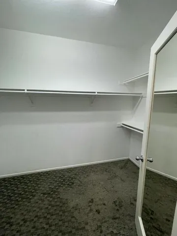 an empty room with windows and fireplace