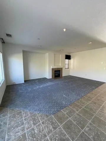 a large kitchen with stainless steel appliances granite countertop a refrigerator a sink dishwasher a stove and a dining table with wooden floor