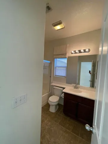 a bathroom with a sink a toilet and mirror